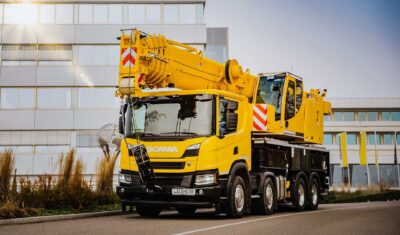 a large yellow truck with a crane on the side